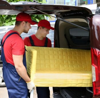 Günstig umziehen in Calw: Umzugshelfer laden ein gelbes Sofa in einen Transporter