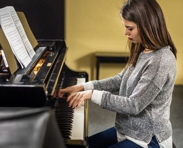 Instrumententransport: Frau spielt an einem Klavier