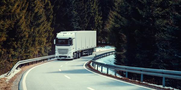 Klaviertransport Calw: Lkw fährt auf einer kurvigen Straße durch den Wald