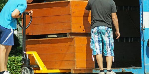 Möbellift Calw: Zwei Helfer tragen einen Holzschrank aus einem Lkw